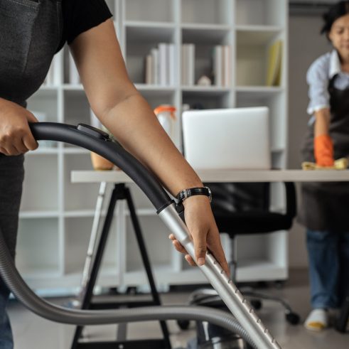 maid housekeeper service wear apron and vacuuming messy dirty floor for housekeeping housework and chores in house.